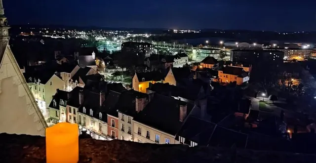 photo  vue sur la médiathèque et l’ombre du plan d’eau du haut de la tour de l’église notre dame des marais éclairée à la bougie.  &copy;  le maine libre 