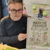 photo  yohan ragaine directeur du centre social avec l’affichedu marché. 