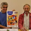 photo  le président des amis de saint-céneri, marc chatain, à droite, et patrick boileau présentent la belle affiche de julien moulin pour les rencontres de la pentecôte. 