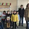 photo les enfants de l’école les marronniers devant leur tout nouveau kiosque à journaux.