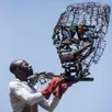 photo dieudonné foukou, présentant une de ses sculptures.