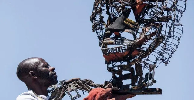 photo  dieudonné foukou, présentant une de ses sculptures.  &copy;  kalbass’art 