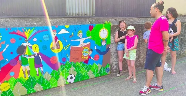 photo  des élèves et l’artiste rb expliquent aux visiteurs la signification de la fresque créée dans la cour.  &copy;  le maine libre 