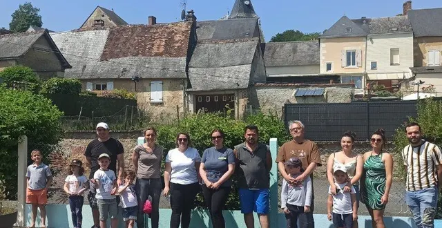 photo  des parents et des élèves posent devant la clôture extérieure peinte aux couleurs de l’arc-en-ciel.  &copy;  le maine libre 