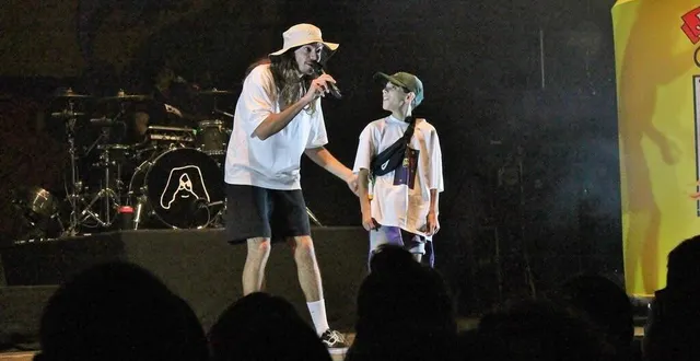 photo  romann, le regard admiratif aux côtés du rappeur lujipeka, sur la scène du festival pop au parc, samedi 1er juillet 2023, à sablé-sur-sarthe.  &copy;  ouest-france 