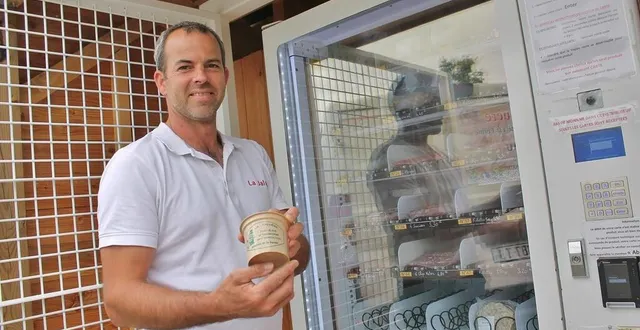 photo  emmanuel fortin avec un pot de rillettes de la ferme la jaluère, devant le distributeur de charcuterie installé à solesmes et remis en service depuis le 28 juillet 2023.  &copy;  ouest-france 