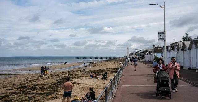 photo  à luc-sur-mer (calvados), les touristes profitent d’une courte éclaircie pour se promener sur le front de mer et sur la plage.  &copy;  martin roche/ouest-france. 