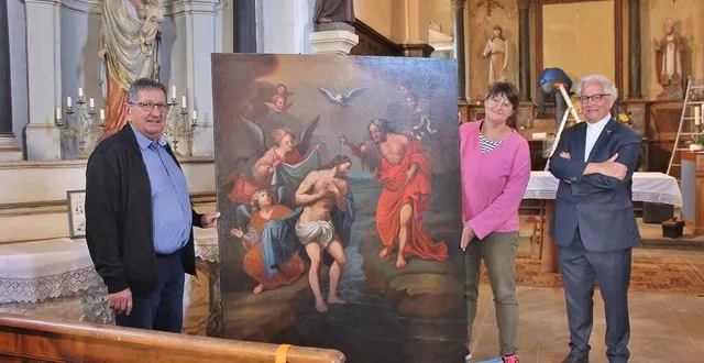 photo  dominique leroy, maire de courtillers, tient le tableau avec fanny chauvet, la restauratrice, et hervé-marie cotten, le curé de l’ensemble paroissial de sablé-sur-sarthe, ce lundi 7 août 2023, dans l’église saint-jean-baptiste.  &copy;  ouest-france 