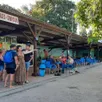 photo la plage accueille famille, amis et campeurs autour des tables du bar.