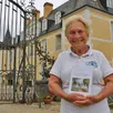 photo  hélène du peyroux, avec son livre, à l’entrée du château de dobert, le 9 août 2023, à avoise. 