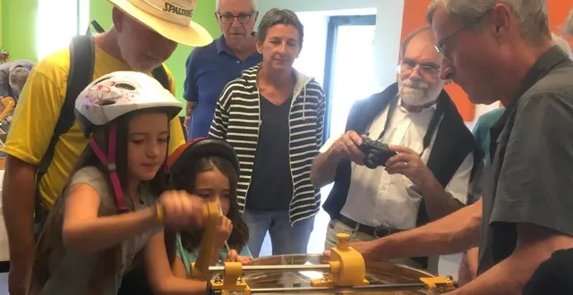 photo  une jeune fille tourne la manivelle de l’extracteur pour faire sortir le miel des alvéoles par centrifugation.  &copy;  ouest-france 