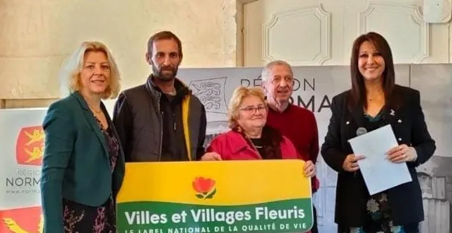photo  gaël comte et annie vail, heureux, derrière leur panneau récompense.  &copy;  @villes et villages fleuris 