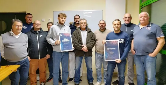 photo  hugo jahier, accompagné de son tuteur david, présentant la pancarte de terre de jeux 2024, entourés par les présidents des clubs.  &copy;  le maine libre 