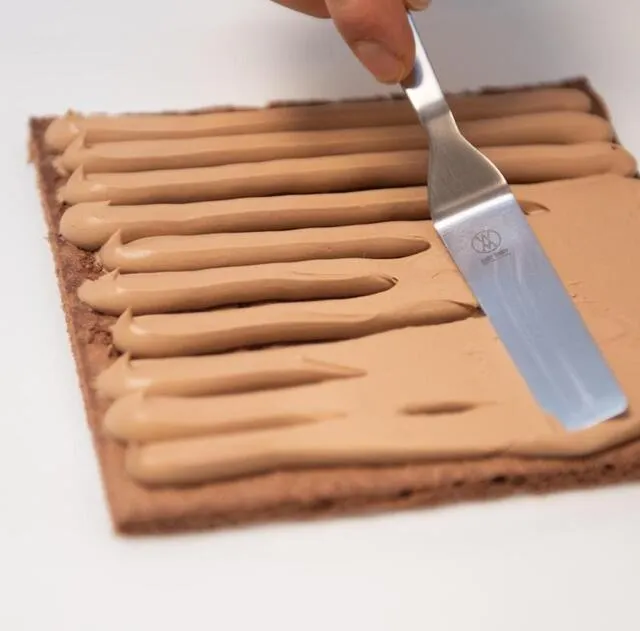 Étaler la ganache sur le biscuit coupé en carré. DAVID ADEMAS / OUEST-FRANCE photo étaler la ganache sur le biscuit coupé en carré. © david ademas / ouest-france