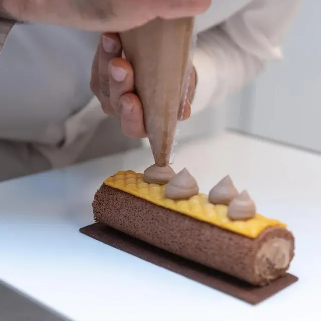 Poser des pointes de ganache avec la poche à douille. DAVID ADEMAS / OUEST-FRANCE photo poser des pointes de ganache avec la poche à douille. © david ademas / ouest-france