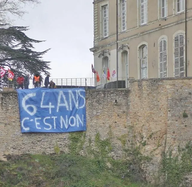 photo cinq manifestants, représentants les cinq syndicats de l’intersyndicale locale ont déployé une banderole pour dire « non » à la retraite à 64 ans, sur les remparts du château de sablé-sur-sarthe, jeudi 6 avril 2023.  ©  ouest-france
