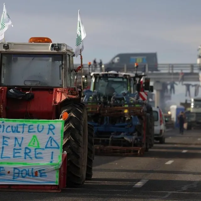 photo cette photographie prise le 22 janvier 2024 montre un tracteur avec une banderole sur laquelle est écrit « agriculteur en colère » alors que les agriculteurs continuent de bloquer l’autoroute a64 pour protester contre la fiscalité et la baisse des revenus, près de carbonne, au sud de toulouse.  ©  valentine chapuis / afp
