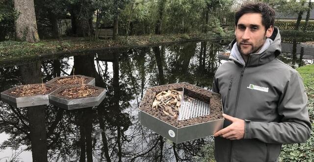photo  ludovic amy présente une maquette du module aloé en aluminium et liège, à côté d’un étang avec ses installations. 