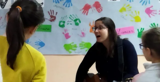 photo  lise leblanc accompagnant les élèves à la guitare.  &copy;  co 