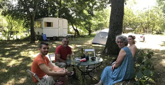 photo  les propriétaires du camping et un couple de campeurs profitent d’un apéro au soleil au camping paysan de la gilberdière, à l’été 2022.  &copy;  archives ouest-france 