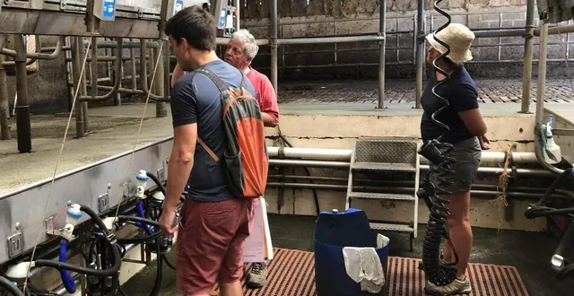 photo  xavier maunoury, agriculteur bio au châtellier (orne), montre sa salle de traite à deux participants du camp alterfixe en 2022.  &copy;  archives ouest-france 