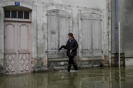 photo Une habitante rentre chez elle après les inondations qui ont touché Montbard, dans le centre-est de la France, le 2 avril 2024. Photo d'illustration. ARNAUD FINISTRE / AFP 