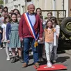 photo  régis bourneuf, maire de tuffé-val-de-la-chéronne, rejoue avec les écoliers la scène de 1944, dans la grande rue. 