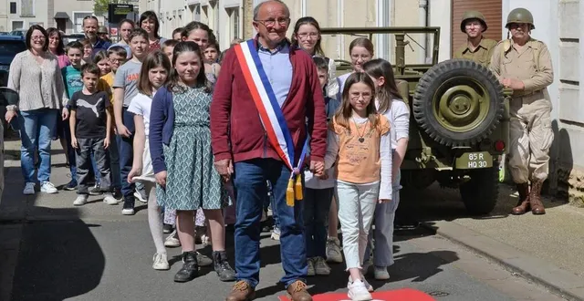 photo  régis bourneuf, maire de tuffé-val-de-la-chéronne, rejoue avec les écoliers la scène de 1944, dans la grande rue.  &copy;  le maine libre 