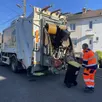 photo  les ripeurs arriment chaque bac jaune qui est ensuite vidé dans la benne. 