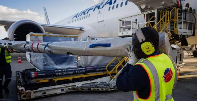 photo  des employés d'aéroports de paris (adp) portent l'équipement de l'équipe française de saut à la perche avant qu'il ne soit chargé dans un avion d'air france, sur le tarmac de l'aéroport roissy-charles-de-gaulle à roissy, au nord de paris, le 16 mai 2024.  &copy;  dimitar dilkoff / afp 