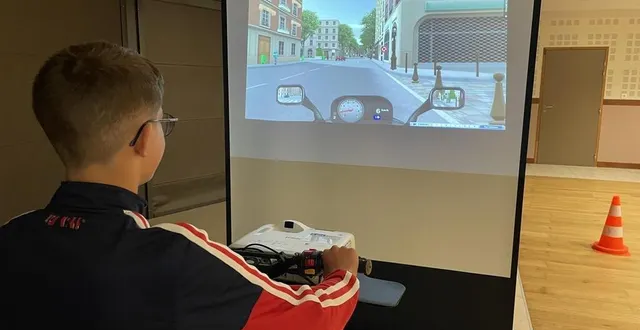 photo  les élèves se sont installés devant un simulateur avant de conduire un vrai scooter, sur le parking de l’hippodrome.  &copy;  le maine libre 