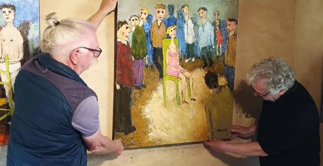 photo  avec l’aide des bénévoles des amis de saint-céneri, le peintre alain ponçon (à droite) accroche ses tableaux dans l’auberge.  &copy;  ouest-france 