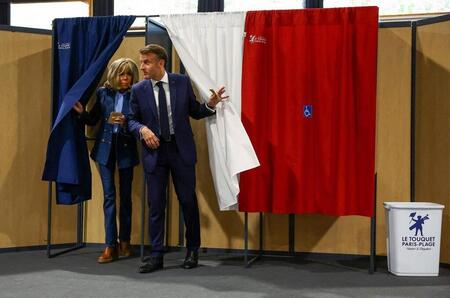 photo Le président Emmanuel Macron et son épouse Brigitte Macron sortent d’un isoloir, après avoir voté pour les élections européennes dans un bureau de vote au Touquet, dans le nord de la France, le 9 juin 2024. HANNAH MCKAY / AFP 