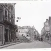 photo argentan pendant l’été 1944, avec le haut de la rue de la chaussée : le tas de gravats, à gauche, correspond à l’ensemble allant actuellement de la parfumerie passion beauté jusqu’au café le brazza.