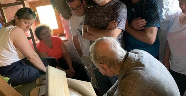 photo  le groupe d’amis venant de normandie écoute les explications de jean fresneau devant la meule au 2e étage du moulin  &copy;  co. 