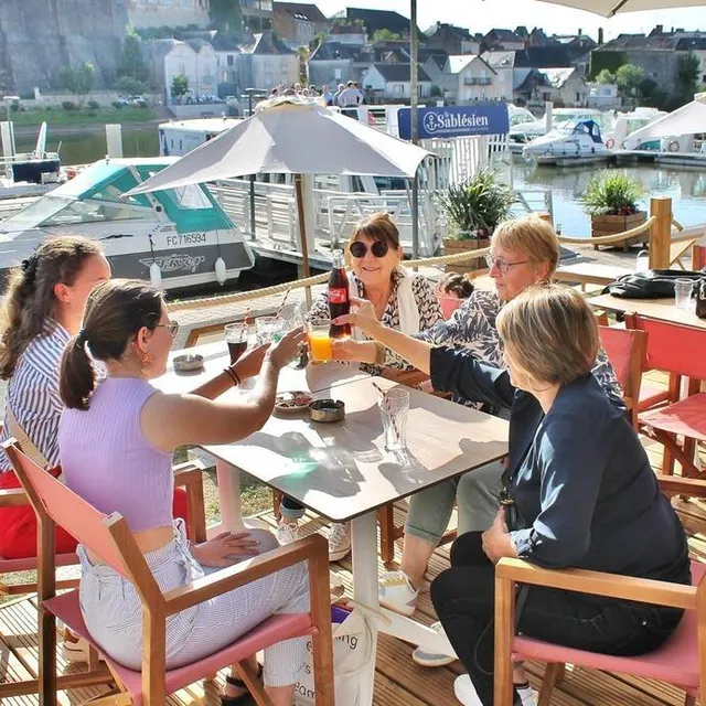 photo les premiers verres en terrasse avec vue sur la rivière, ses bateaux et les remparts du château.  ©  ouest-france