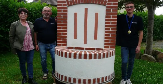 photo  maryse et fabrice dugué posent avec mathys ménard, portant fièrement sa médaille d’or, près de la fontaine, sujet du concours.  &copy;  le maine libre 