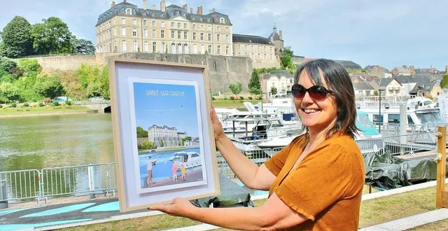 photo  catherine paulouin présentant l'affiche dédiée à sablé-sur-sarthe, avec le château comme emblème.  &copy;  ouest-france 