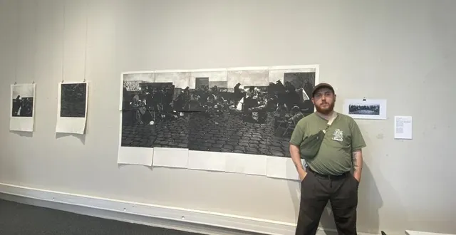 photo  thomas lambert artiste, posant à côté de l’œuvre « orchestre transversal » de l’exposition 