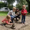 photo les enfants de la famille normande jouent avec la boue laissée par la pluie.