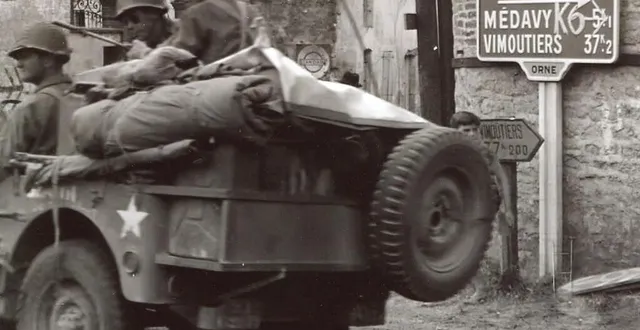 photo  une colonne de jeeps américaines se dirige vers sées. le marquage allemand k6 sur le panneau de signalisation indique la colonne n°6 menant de vimoutiers à lisieux.  &copy;  nara 