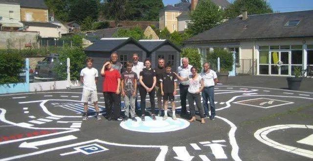 photo  les jeunes posent avec les représentants de la municipalité dans la cour de récréation relookée.  &copy;  le maine libre 