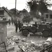 photo photo prise le 21 août 1944, au carrefour des trois-croix (la colonne, à gauche). au fond, les alliés arrivent de la rue des petits-fossés. le véhicule à droite semble venir de la route de trun, voie par laquelle les allemands retraitent.