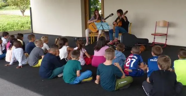 photo  les enfants de ce-ce2 ont attentivement écouté le concert de guitare sous le préau de leur école.  &copy;  le maine libre 