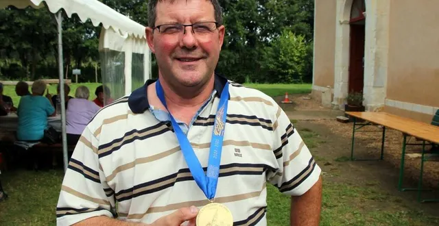 photo  patrick jouenne pose avec la médaille commémorative au cordon bleu, couleur associée à la sainte vierge. les logos des entreprises de charpente figurent au dos de la médaille.  &copy;  le maine libre 