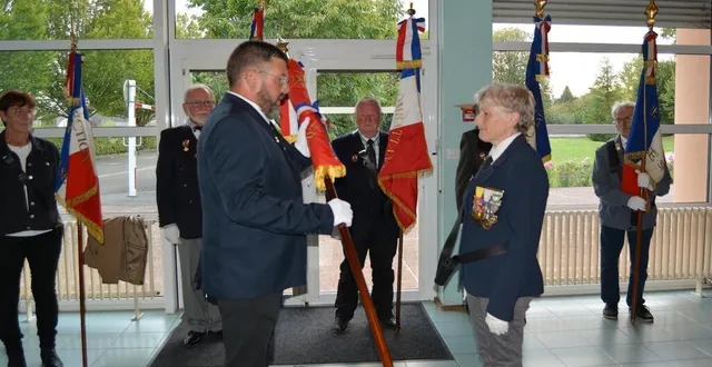 photo  fabrice schnekenburger remet le nouveau drapeau des unc à marie-christine tardif.  &copy;  ouest-france 