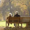 photo  un couple de retraités assis sur un banc dans un parc à l’automne 