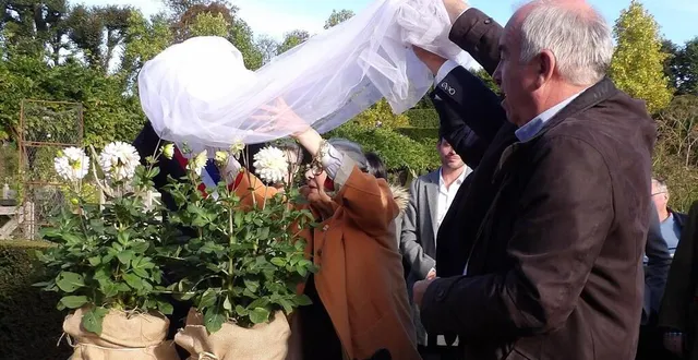 photo  aidée par alain baraton, la marraine du jour, myriam de romans, dévoile le dahlia château colbert.  &copy;  ouest-france 