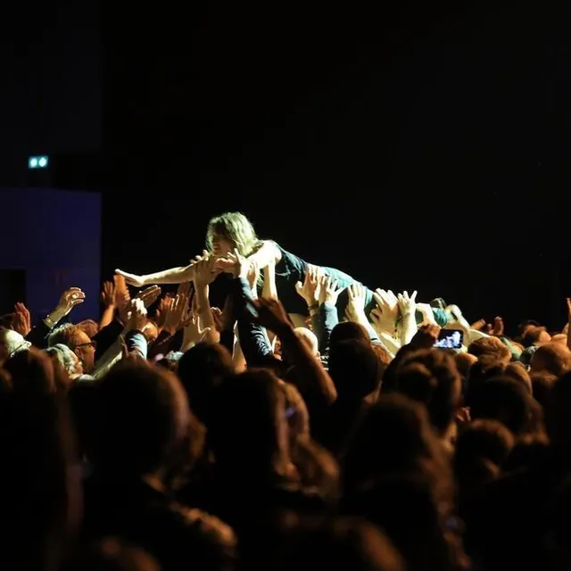 photo en fin de concert, une spectatrice a partagé la scène avec le groupe et fut invitée à nager sur le public… sacré souvenir pour elle !  ©  ouest-france