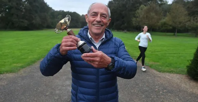 photo  saint-barthélemy-d’anjou, parc de pignerolle, 27 octobre 2024. alain dohin brandit la coupe qui figure encore en bonne place chez lui : celle remportée il y a 50 ans au 1er cross du courrier de l’ouest dans la catégorie des moins de 35 ans non licenciés.  &copy;  co - michel durigneux 